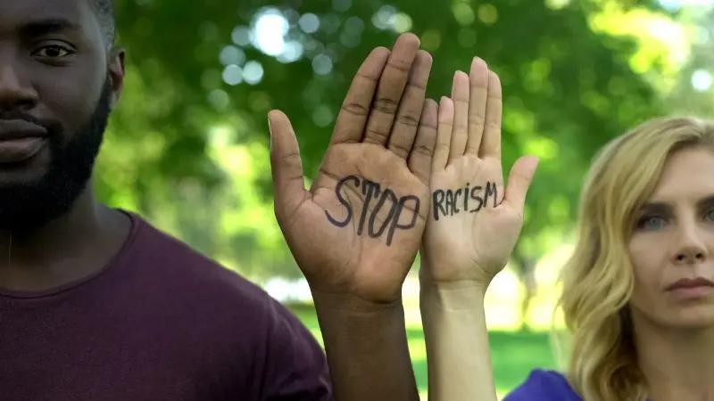 Man and woman with Stop Racism written on their palms