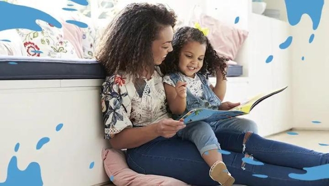 Woman with child on her lap looking at a book